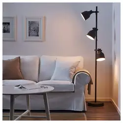 Kreslo və döşəmə lampası ilə qonaq otağının interyeri