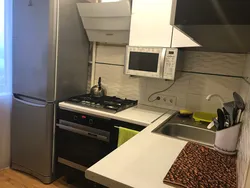 Дизайн кухни с холодильником у окна и газовой плитой