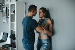 Photo of someone standing against the wall of an apartment