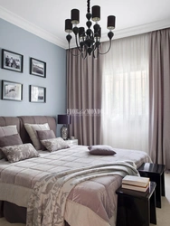 Curtains in the interior of a bedroom with a gray bed