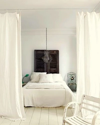 Интерьер спальни с кроватью за шторами