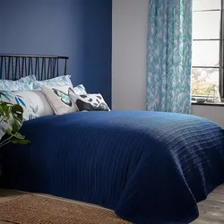 Шторы в интерьере спальни с синей кроватью