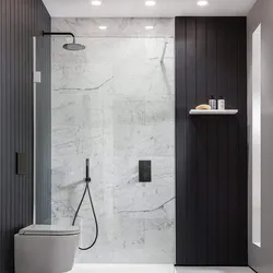 Black shower cabin in the interior of a white bath