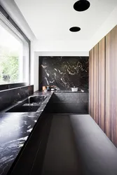 Kitchen With Black Countertop And Marbled Splashback Photo