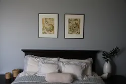 What kind of paintings are hung in the bedroom above the bed photo