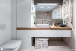 Photo of a bathroom countertop under the sink and washing machine