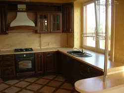 Photo of a kitchen in a house with a window and a bar counter