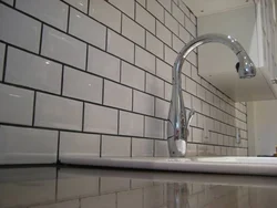 Photo of white tiles with black grout in the bathroom