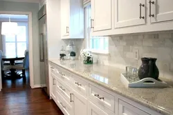 White kitchen with marble countertop and apron in the interior