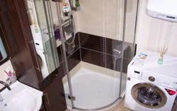 Photo of a bathroom with a shower and a washing machine without a toilet