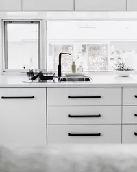Дизайн белой кухни с черными ручками