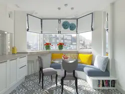 Интерьер кухни гостиной с диваном у окна