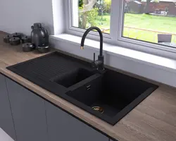 Photo of a kitchen with a white countertop and a black sink