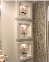 Қабырғадағы фотосуреттегі плиткалардан жасалған ванна бөлмесіндегі сөрелер