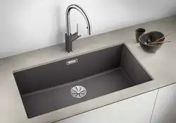 Kitchen sinks built into countertops made of artificial photo