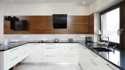 White kitchen with wooden countertop and black handles in the interior