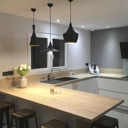 Pendant lamps above the bar counter in the kitchen in the interior