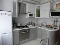 Corner kitchen design photo with refrigerator by the window