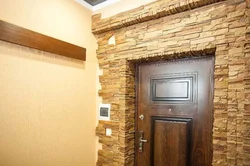 Finishing doors with decorative stone in the hallway photo