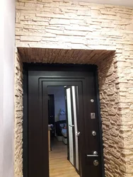 Finishing doors with decorative stone in the hallway photo