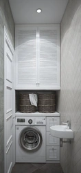 Ванна бөлмесінің интерьеріндегі фотосуреттегі кір жуғыш машинаның үстіндегі шкаф
