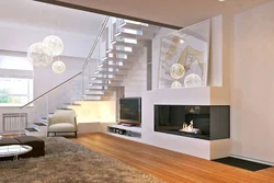Дизайн гостиной с лестницей и камином