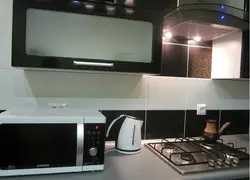 Чорная мікрахвалеўка на кухні фота