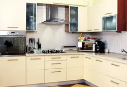 Photo of a beige kitchen with a hood