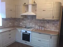 Photo of a beige kitchen with a hood