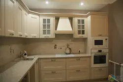 Photo of a beige kitchen with a hood