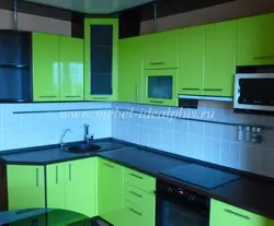 Green kitchen with black countertop photo