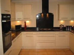 Black appliances in a beige kitchen photo