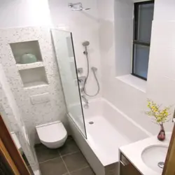 Toilet between bathtub and sink photo
