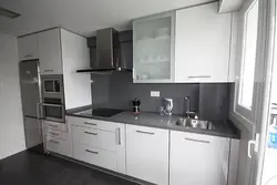 Photo of white kitchen with gray appliances