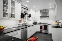 Photo of white kitchen with gray appliances