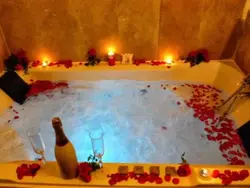 Bath with rose petals and candles photo