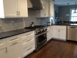 White kitchen with dark gray countertop photo