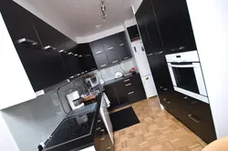 Интерьер фотодағы ақ асүйдегі қара тоңазытқыш