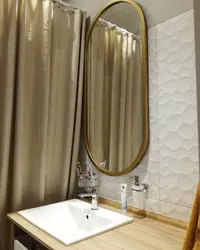 Oval mirror in the bathroom interior