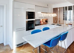 Blue chairs in the interior of a white kitchen