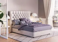 Beige bed with a soft headboard in the bedroom interior