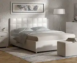 Beige bed with a soft headboard in the bedroom interior