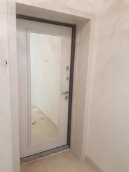 Kiçik bir giriş koridorunun içərisində güzgü ilə qapı