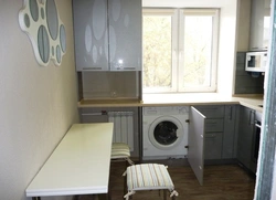 Kitchen design with a refrigerator by the window and a gas stove