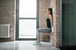 Photo of someone standing against the wall of an apartment