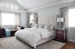 Curtains in the interior of a bedroom with a gray bed