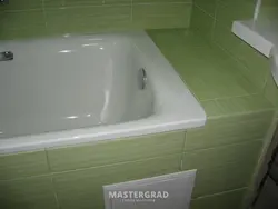 Photo of the bathtub covered with tiles