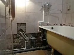 Photo of bathtub tiles and pipes