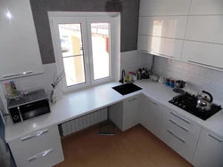 Photo of a kitchen with a refrigerator and a table