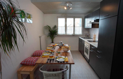 Photo of a kitchen with a refrigerator and a table